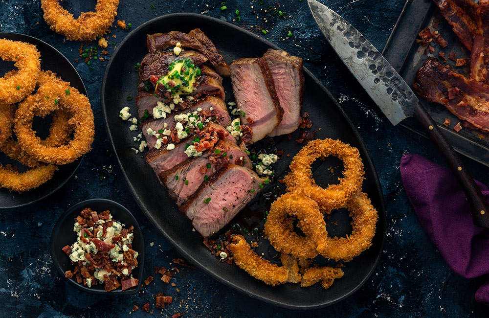 New York Strip Steak with Blue Cheese Bacon Crumble & Panko Onion Rings